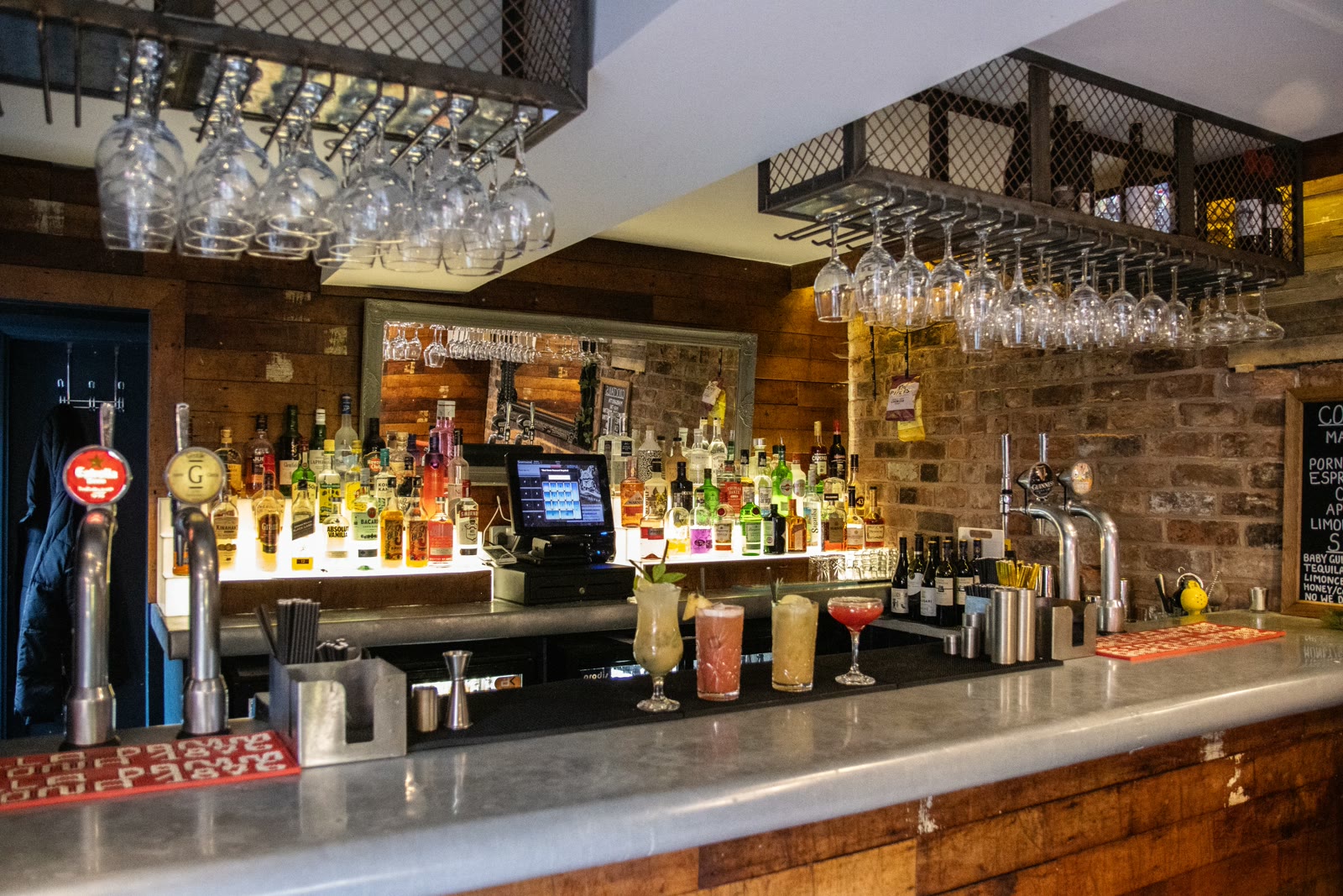 The bar at The Ivy League, Altrincham, lit by hanging glass pendants